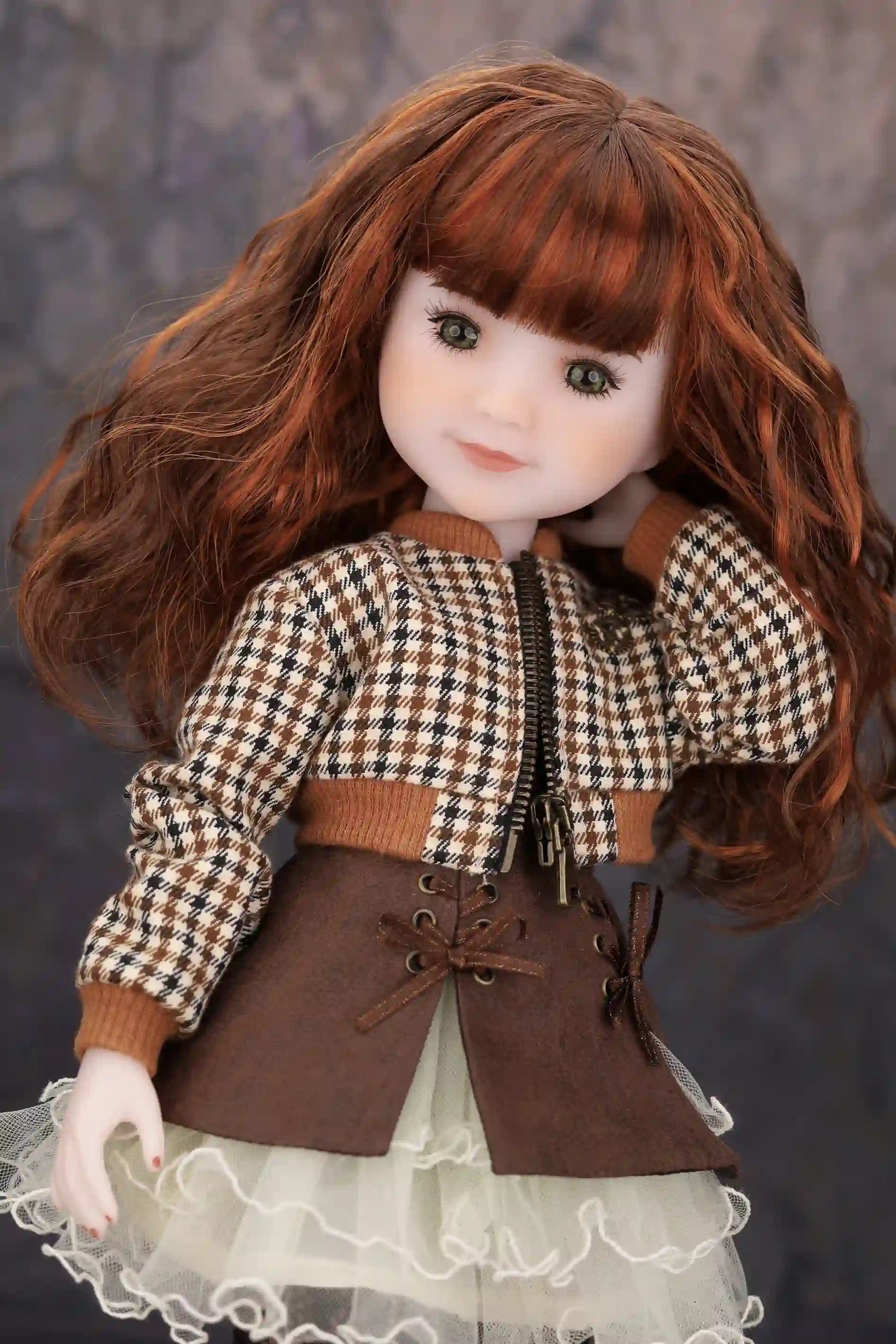 Doll with checkered jacket and brown skirt against a dark background