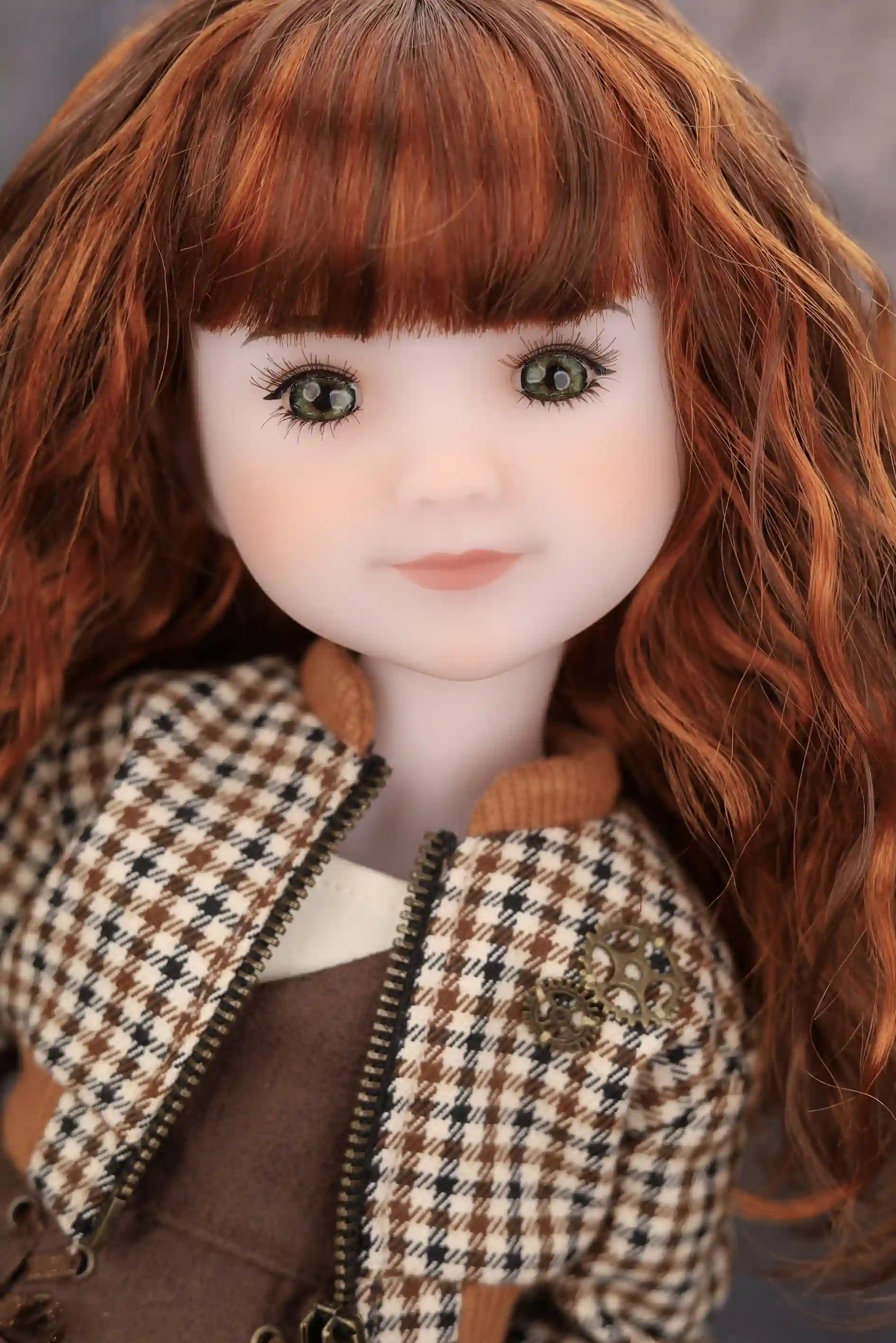 Doll with red hair wearing a plaid jacket against a neutral background