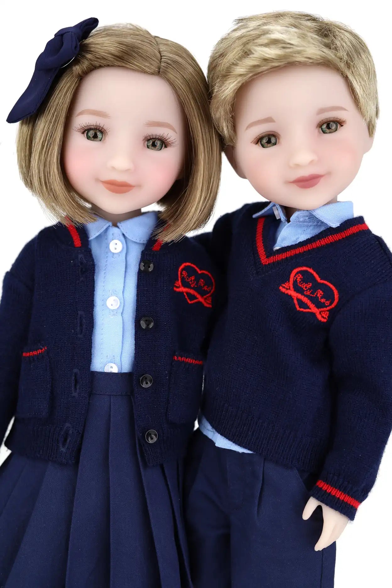 Two dolls in matching navy blue outfits with red accents on a white background