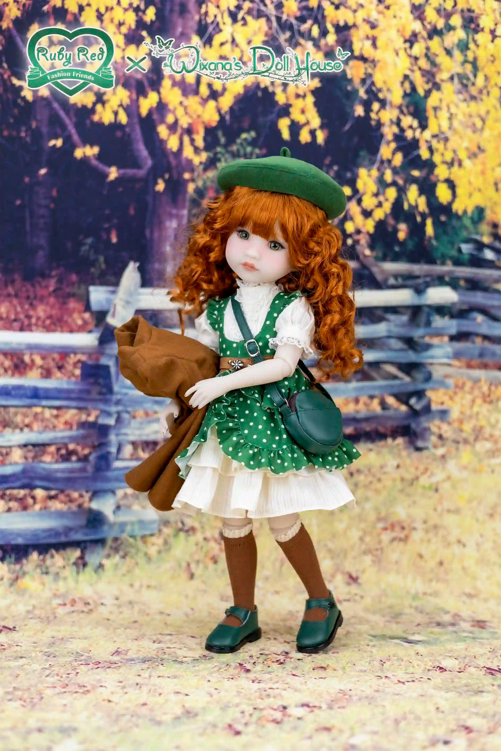 Doll with red hair and green outfit standing in a scenic outdoor setting with a wooden fence and trees.