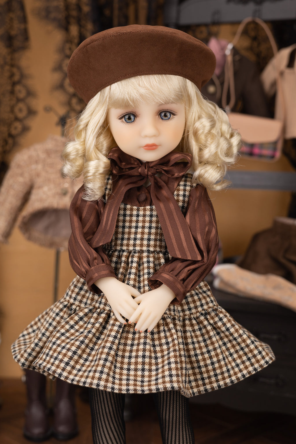 Doll wearing a brown beret and checkered dress with a blurred background