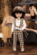 Doll in plaid outfit with hat in a room with vintage clothing and furniture