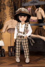 Doll in plaid outfit with hat in a room with vintage clothing and furniture