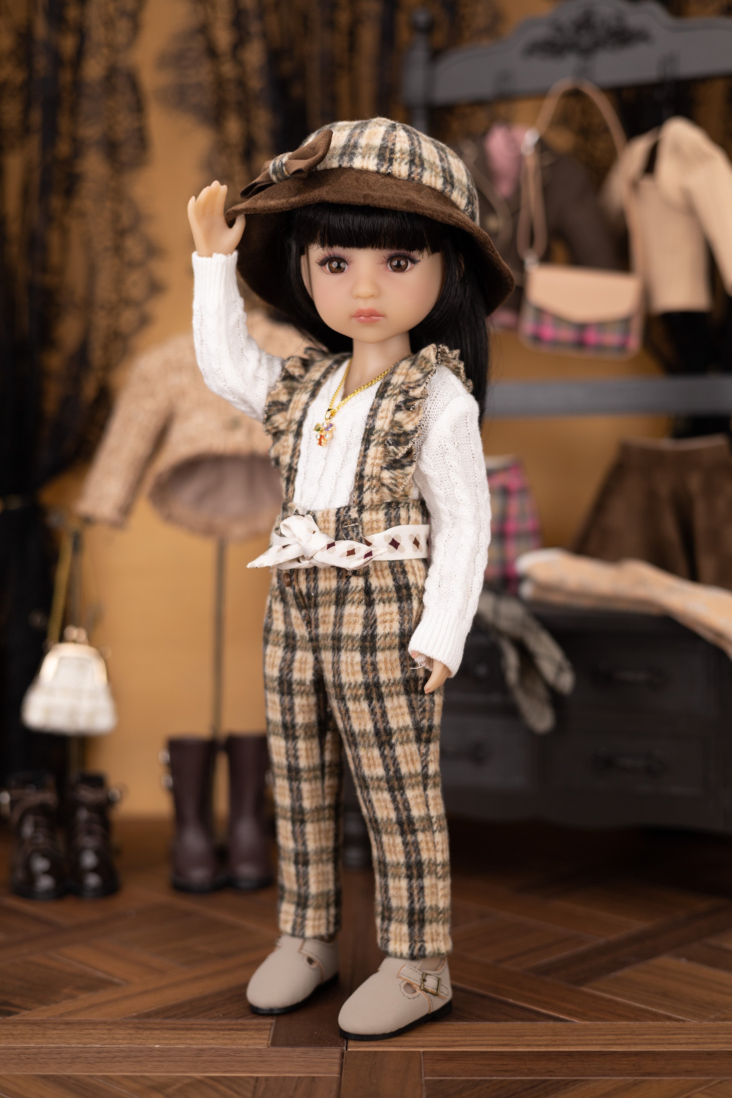 Doll in plaid outfit with hat in a vintage-style room