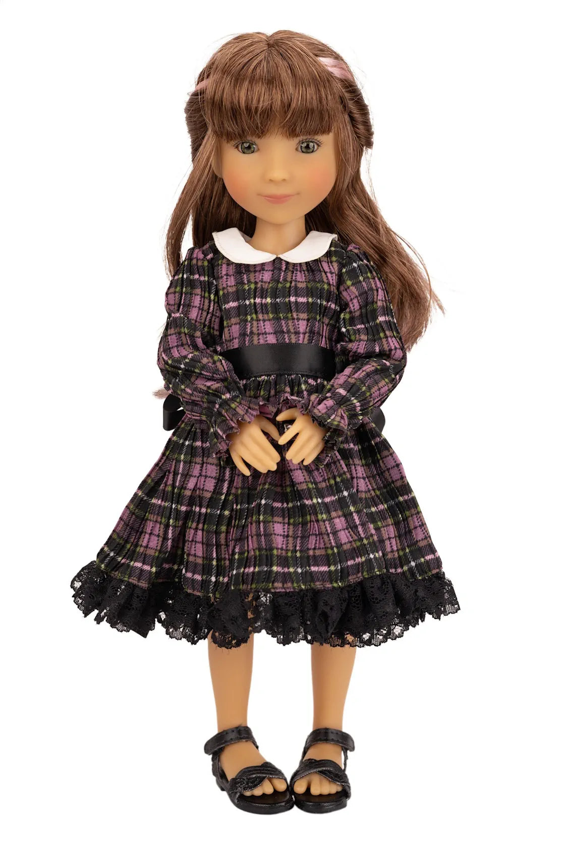 Doll wearing a plaid dress with a white collar on a white background