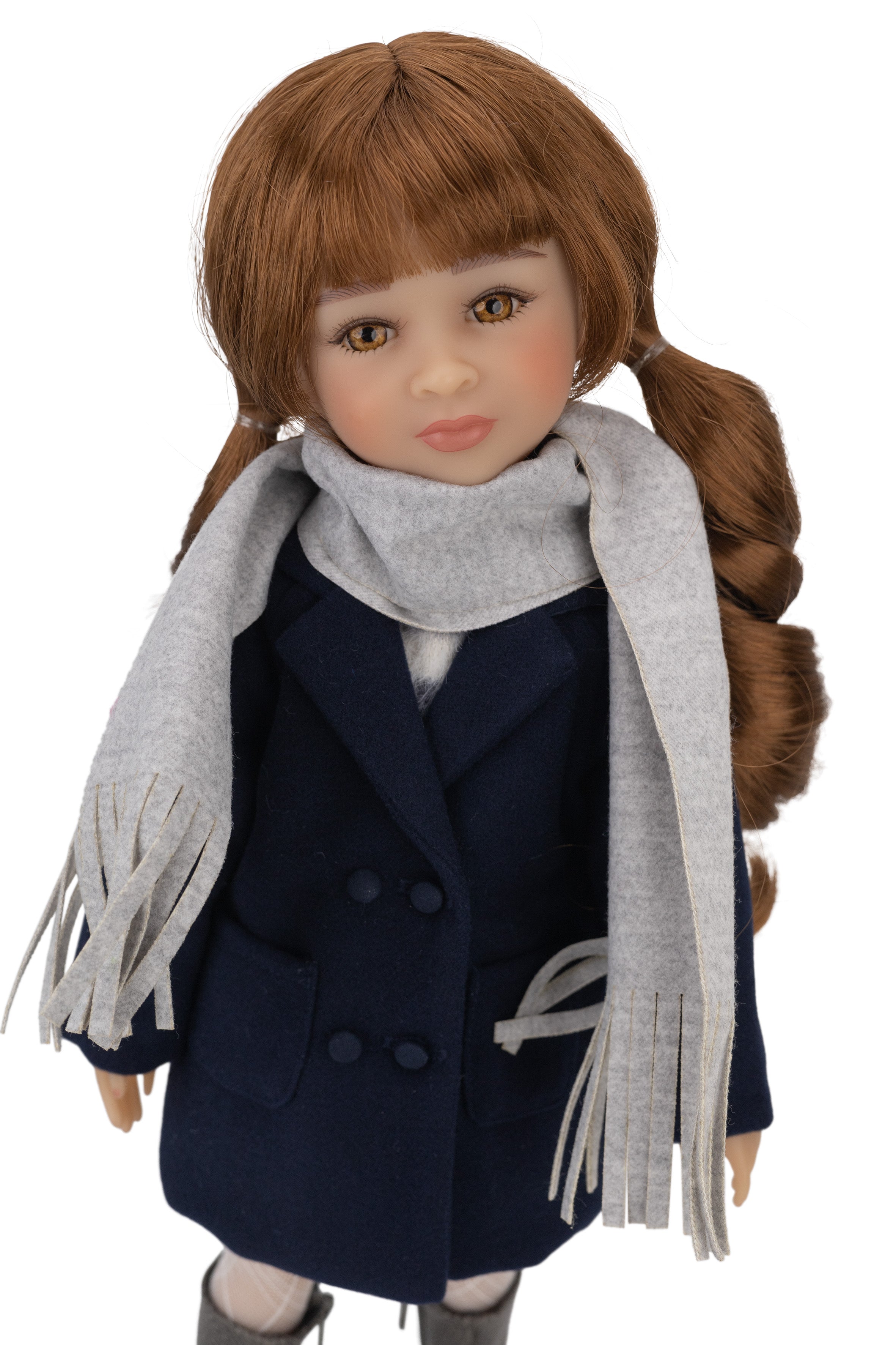 Doll wearing a navy coat and gray scarf on a white background