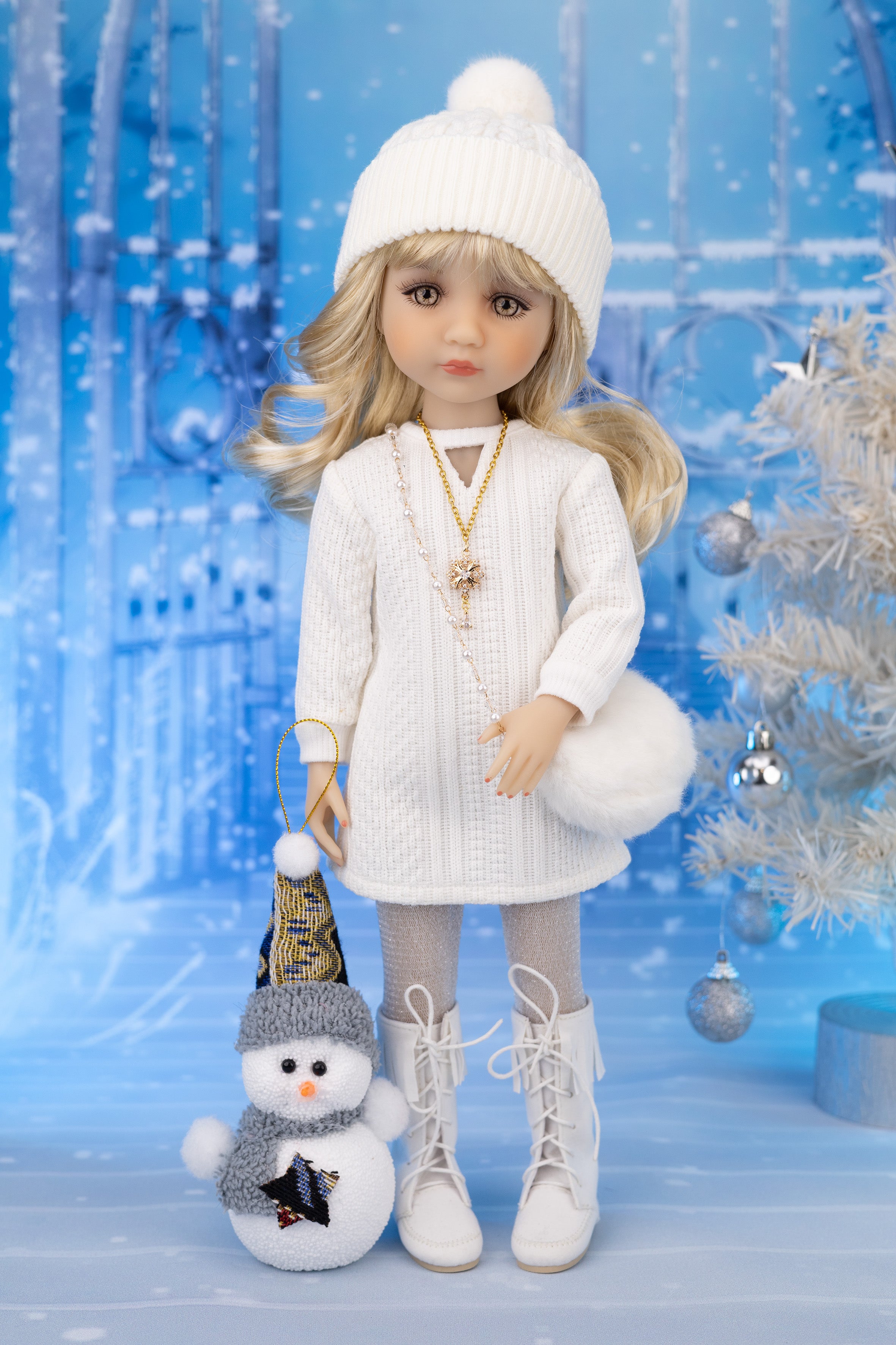 Doll in winter outfit with snowman toy against a blue snowy background