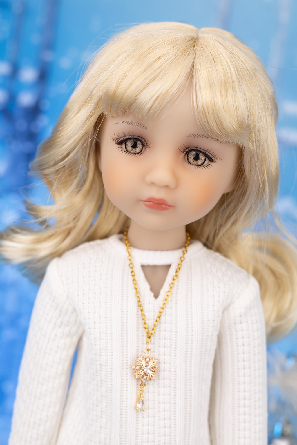 Doll with blonde hair and a white outfit against a blue background