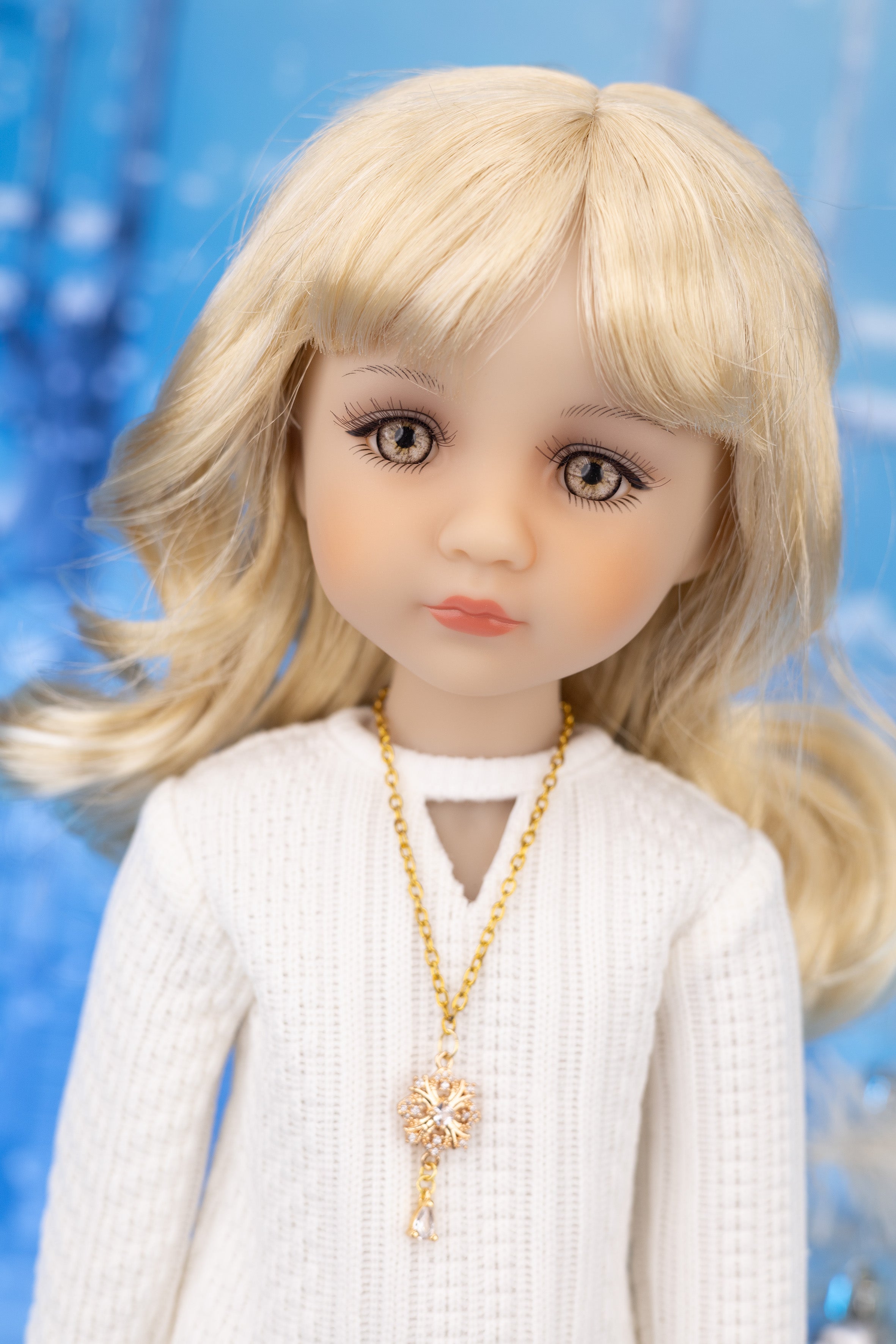 Doll with blonde hair and a white outfit against a blue background