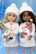Two dolls wearing white outfits with snowmen, against a blue water fountain background.