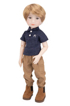 Doll wearing a navy blue shirt with white buttons and brown pants on a white background