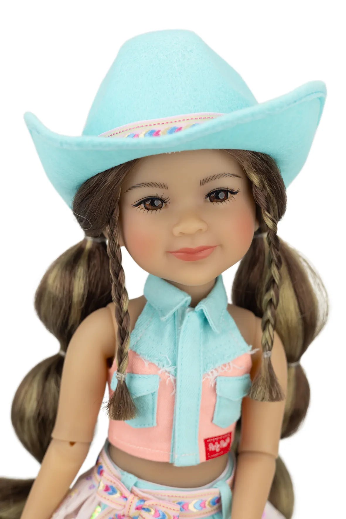 Amina wearing a turquoise cowboy hat and matching outfit with a pink top and colorful skirt.
