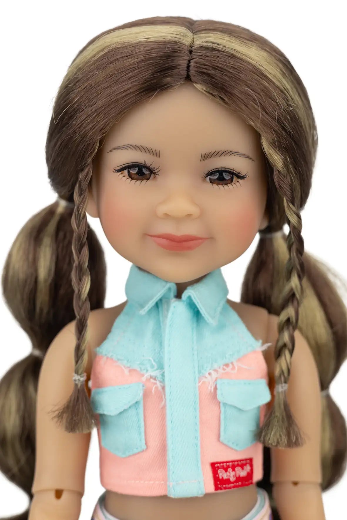 Amina with braided hair wearing a light blue shirt over a pink top with a visible brand label.