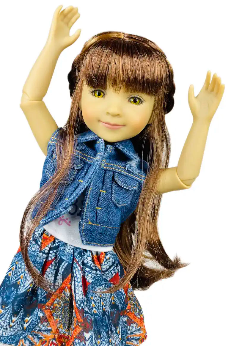 Bella with long brown hair wearing a denim vest over a colorful dress on a white background