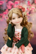 Eden with floral headband and outfit against a blurred floral background