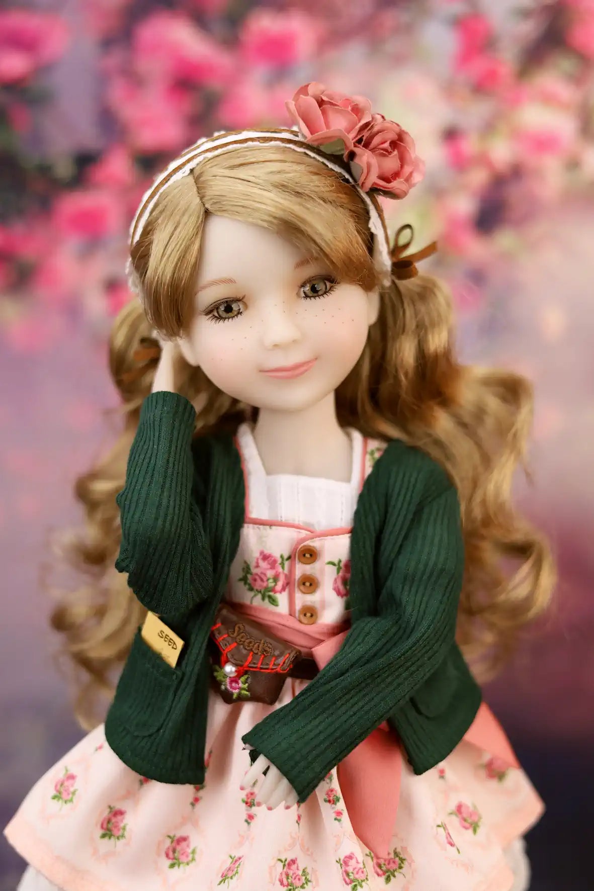 Eden with floral headband and outfit against a blurred floral background
