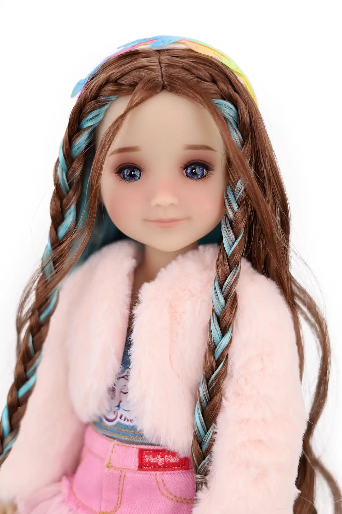 Ella with braided hair wearing a colorful headband, pink fur vest, and pink pants on a white background