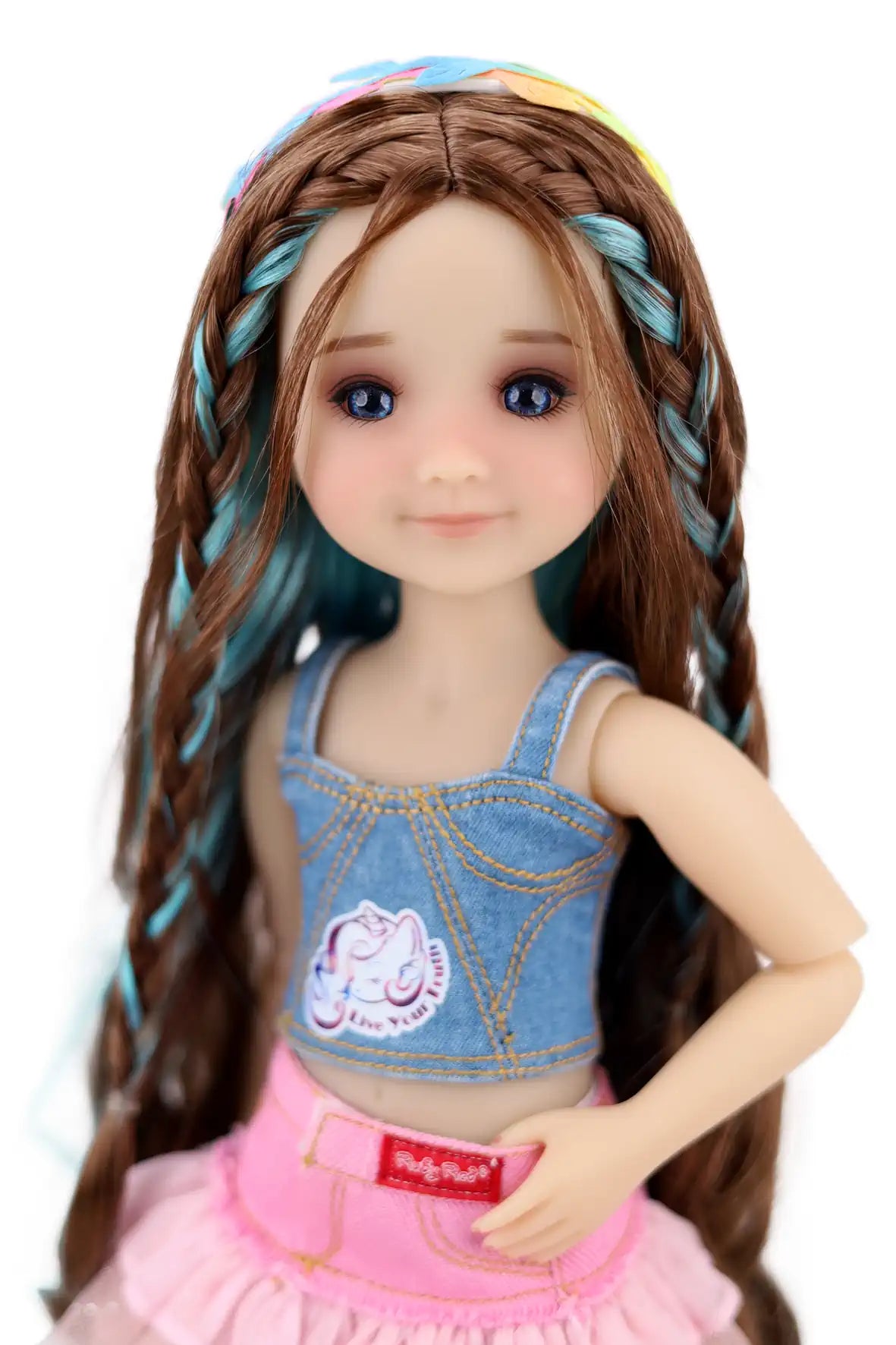 Ella with braided hair wearing a denim top and pink skirt on a white background