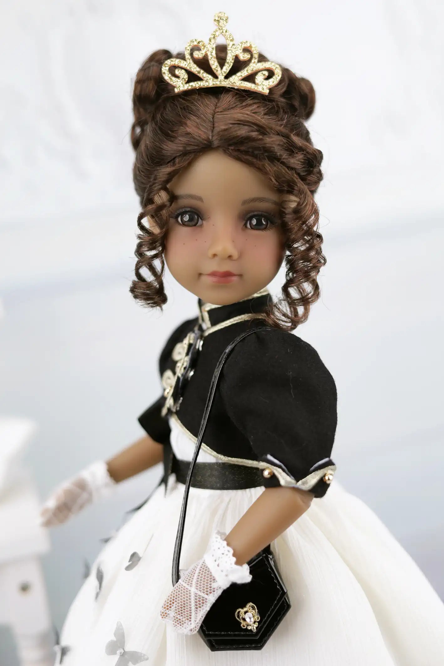Esther in a formal outfit with a tiara on a light gray background