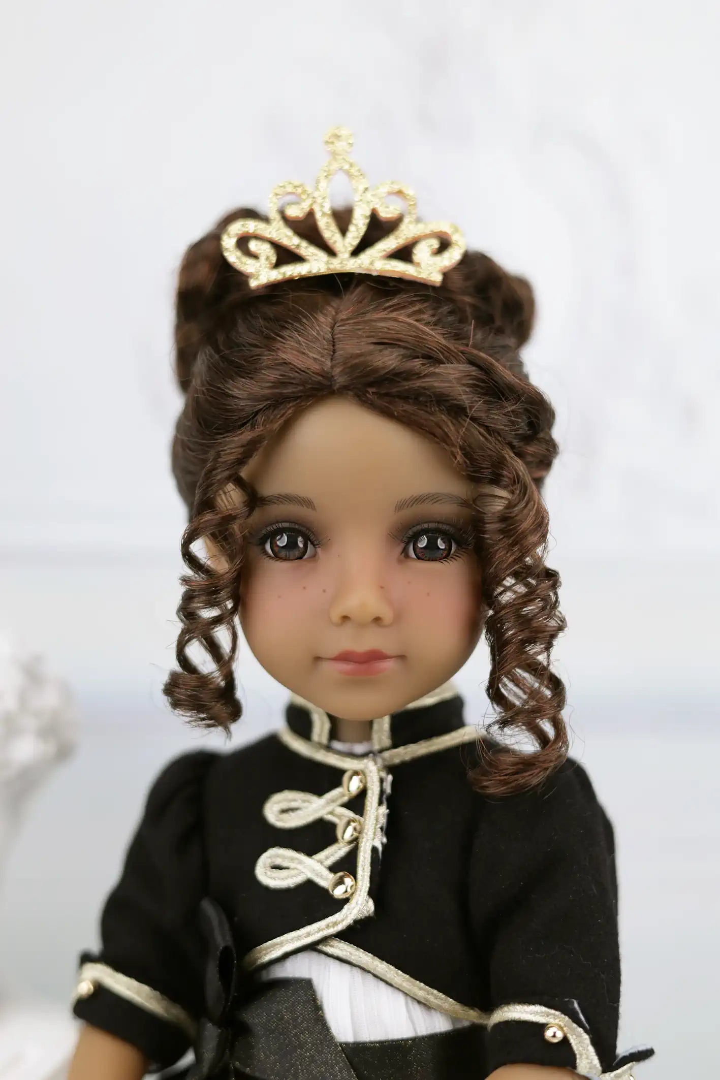 Esther with a black outfit and gold tiara on a white background