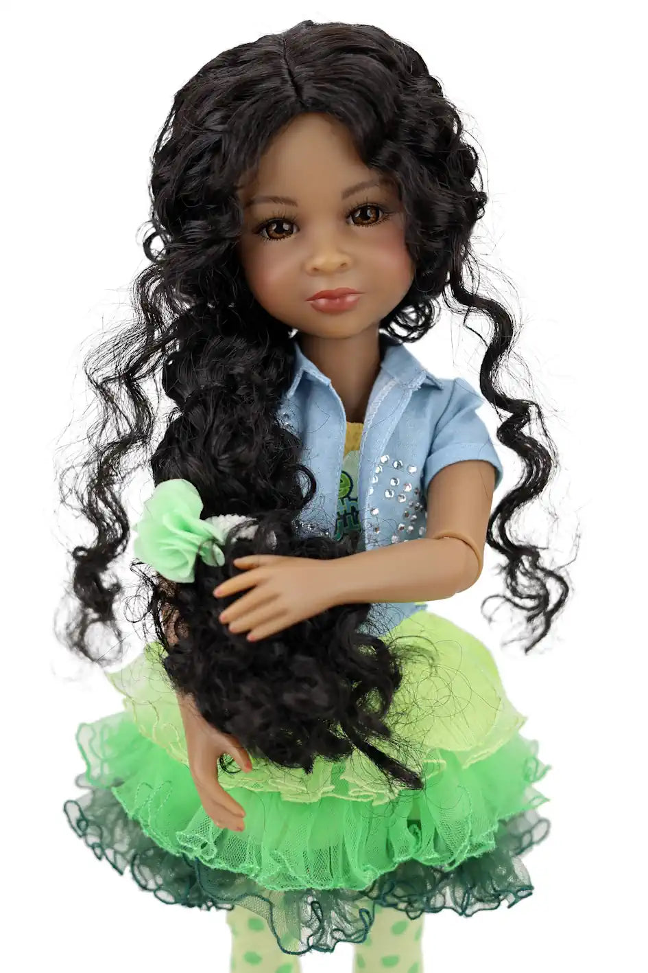 Jada with long black hair wearing a green dress and blue jacket holding a black dog.