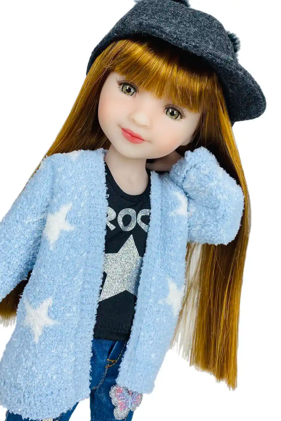 Stella wearing a blue jacket with star patterns, black hat, and star-themed shirt on a white background