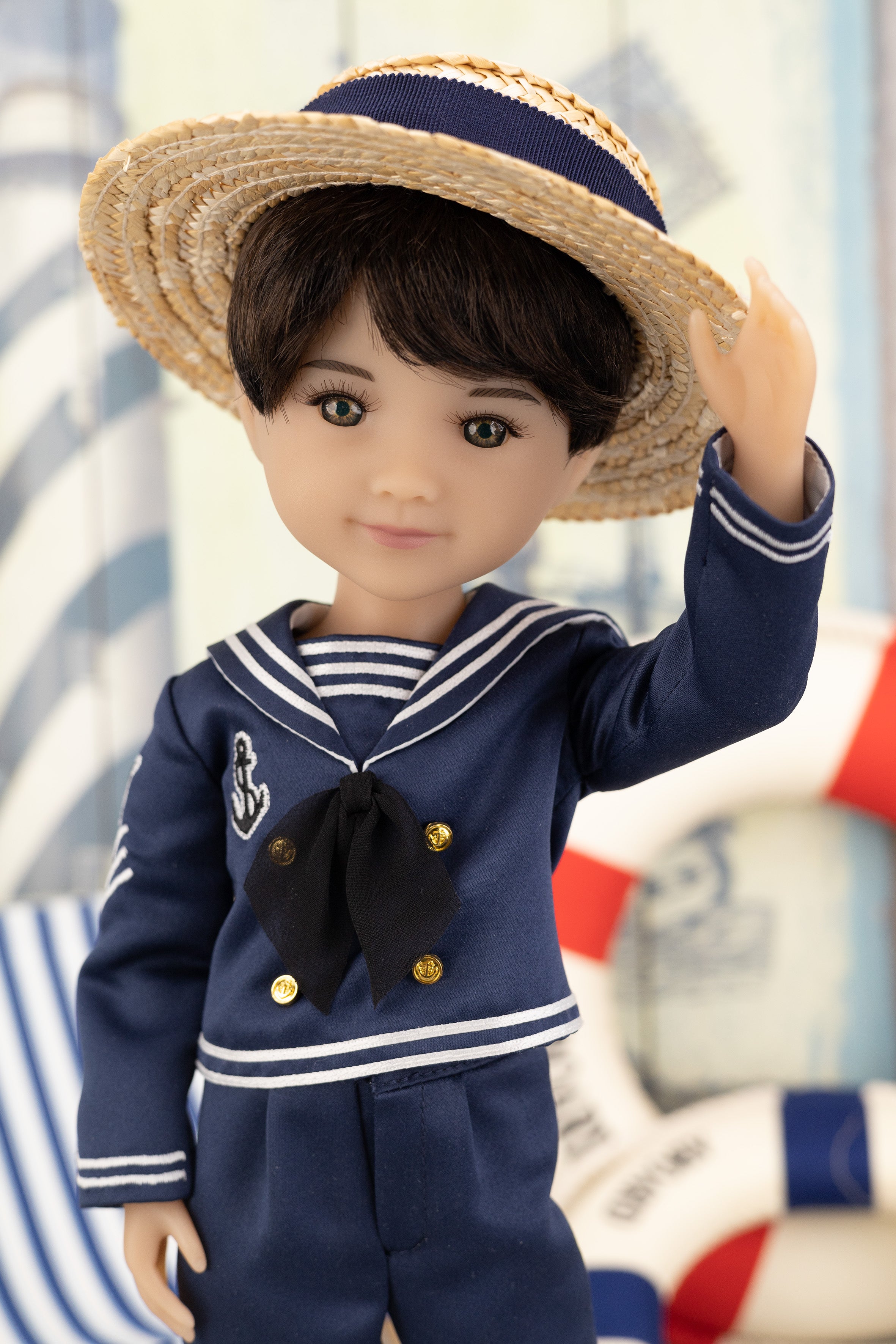 Tyler in a navy blue sailor outfit with a straw hat against a blurred background