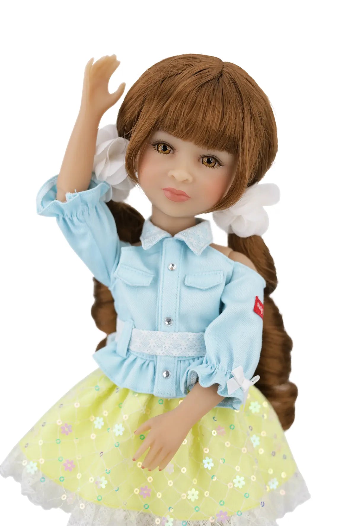 Valeria wearing a light blue shirt and yellow skirt with floral patterns on a white background