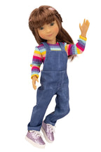 Doll wearing a colorful striped shirt and blue overalls on a white background