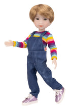 Doll wearing a colorful striped shirt and blue overalls on a white background