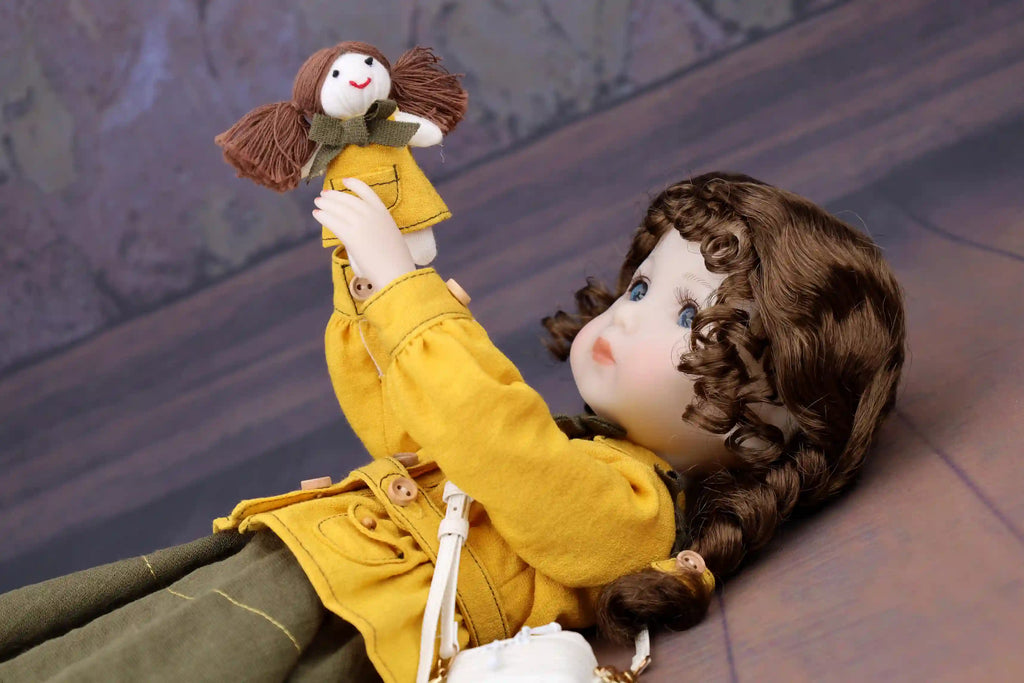 Doll in a yellow coat holding a smaller doll against a textured wall background