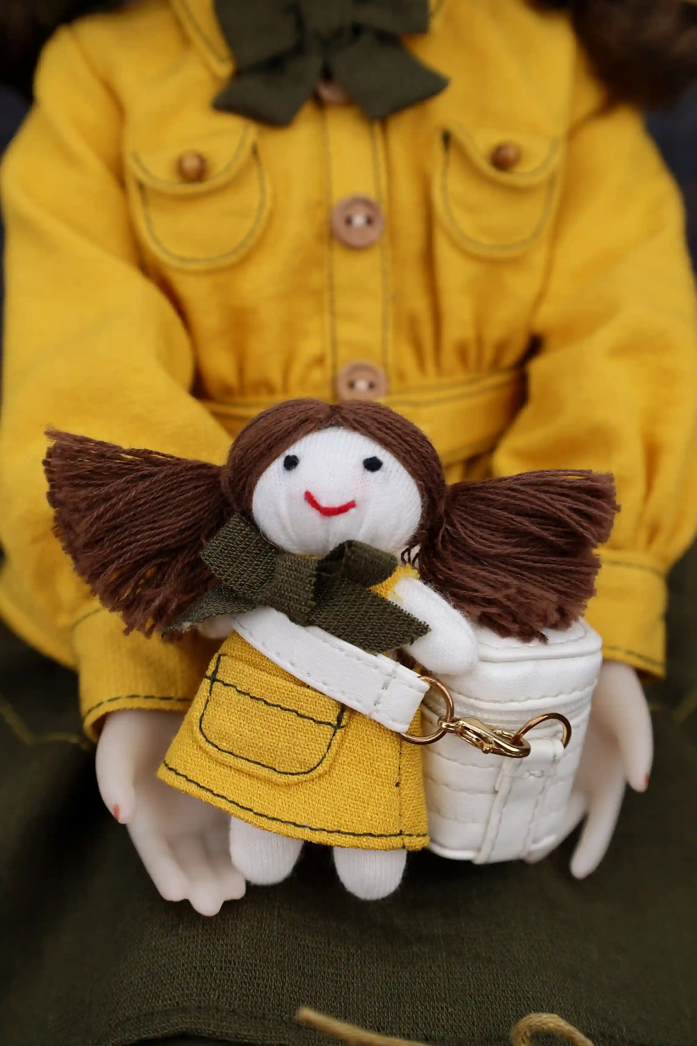 Small angel figurine held by a person wearing a yellow coat.