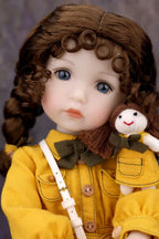 Doll in a yellow coat holding a smaller doll with a plain background