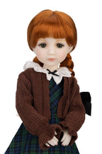 Doll with red hair styled in pigtails, wearing a brown sweater and plaid skirt on a white background