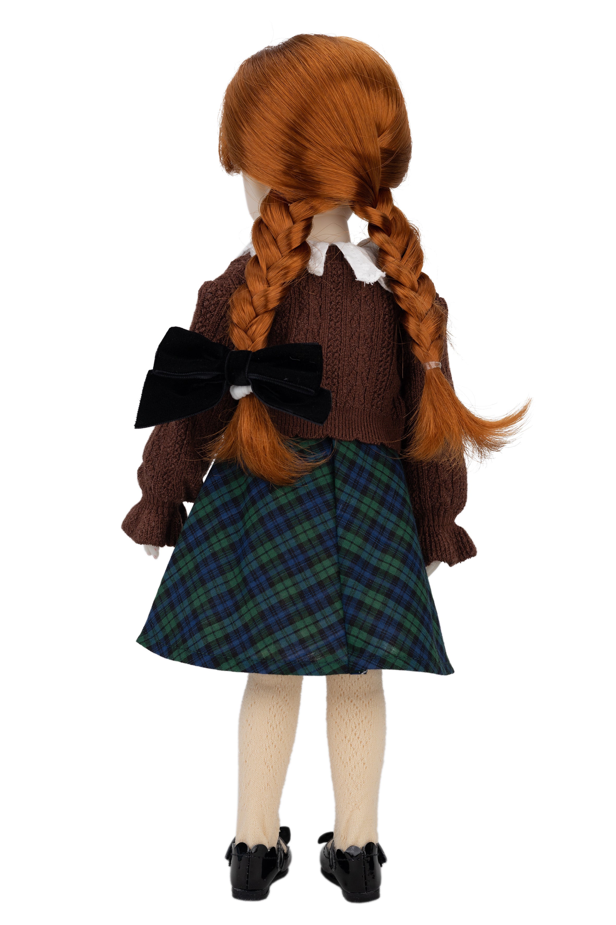 Doll with red hair styled in braids, wearing a brown sweater and plaid skirt on a white background