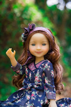 Doll with floral dress and headband against a blurred natural background