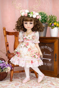 Doll in a floral dress with a pink background