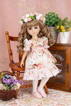 Doll in a floral dress sitting on a chair with decorative background