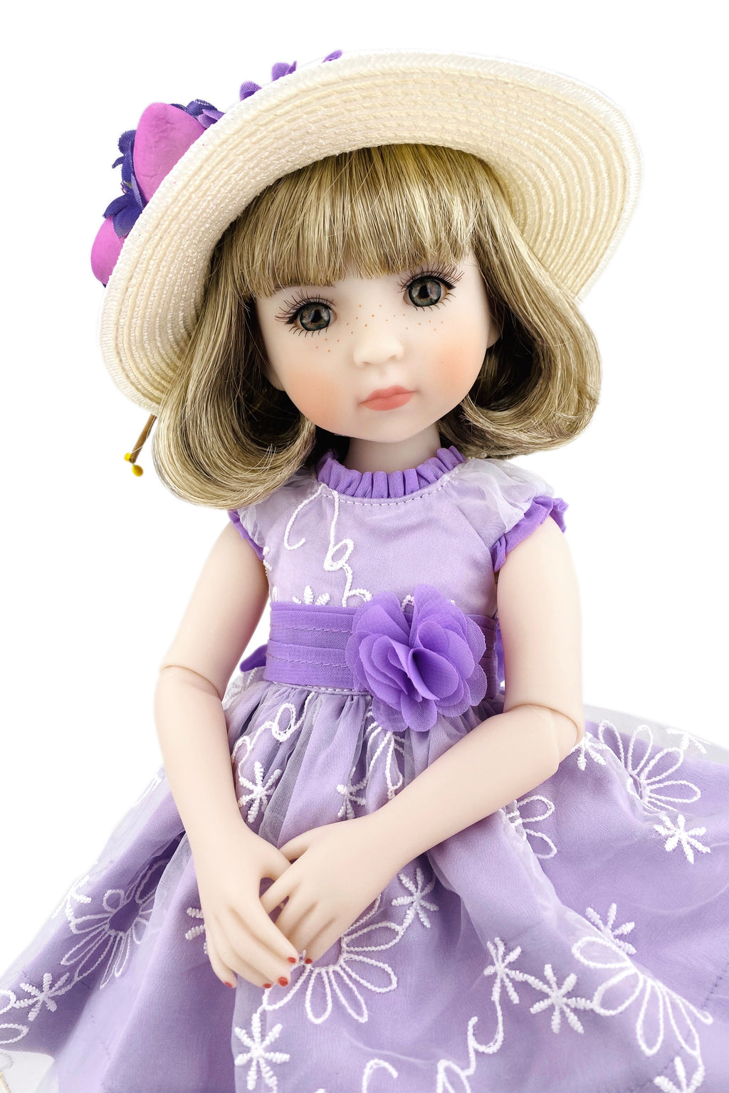 Doll in a purple dress with floral details and a matching hat on a white background