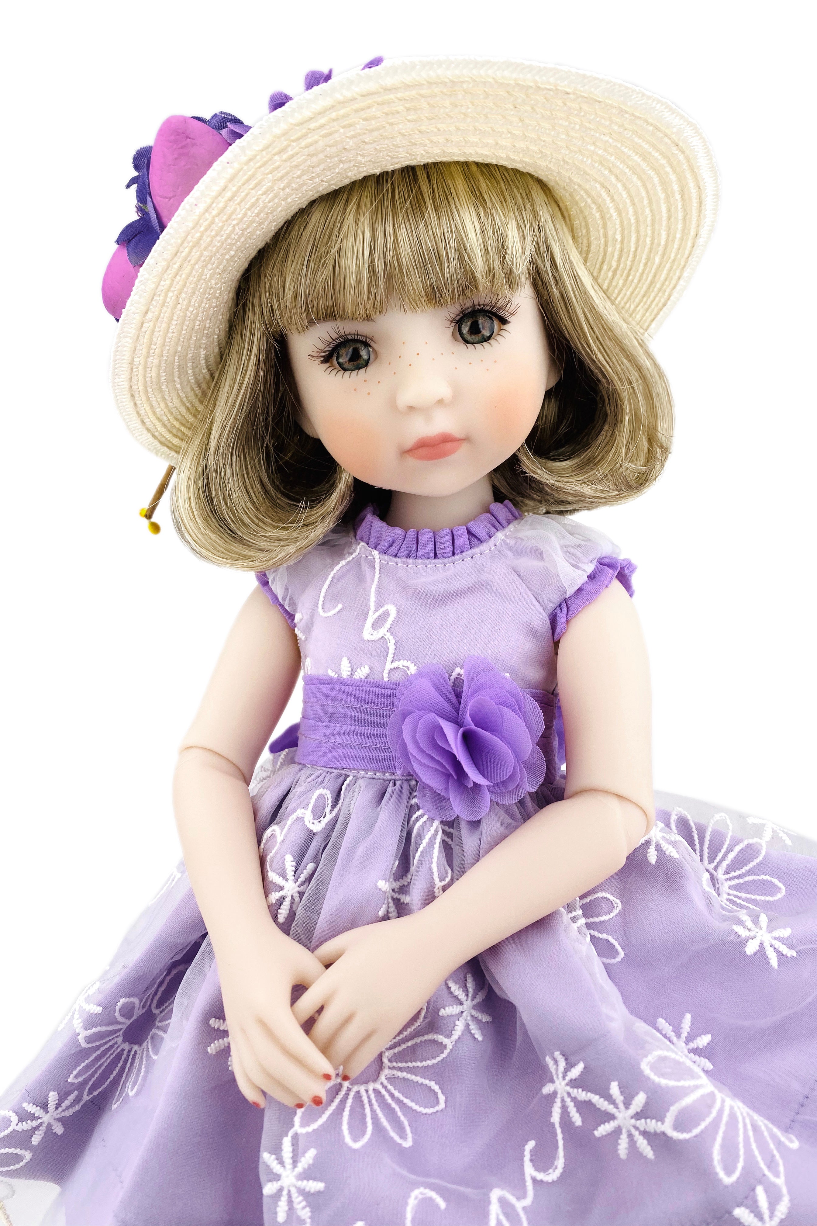 Doll in a purple dress with floral details and a matching hat on a white background