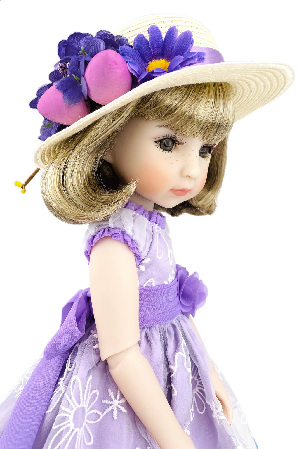 Doll wearing a purple dress and hat with flowers on a white background