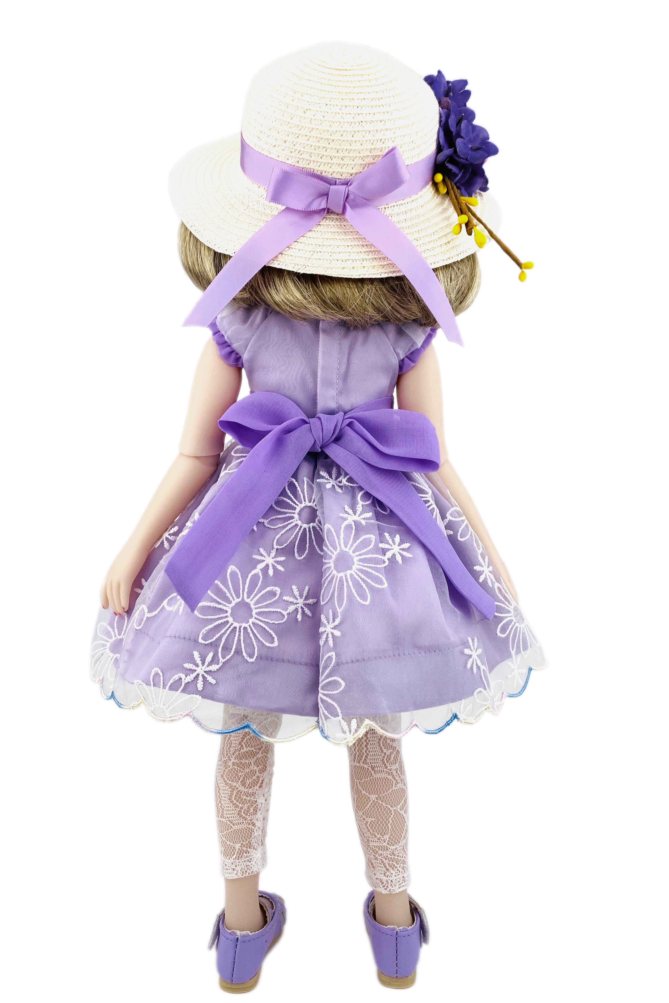 Doll wearing a purple dress with floral patterns and a matching hat on a white background