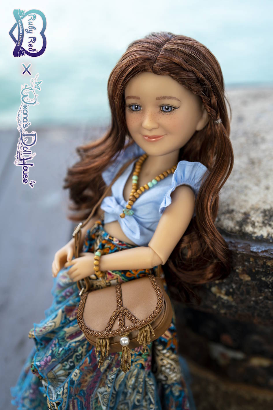 Doll with long brown hair wearing a blue top and colorful skirt, sitting on a stone surface.