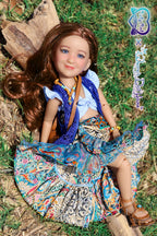 Doll with a colorful outfit sitting on grass