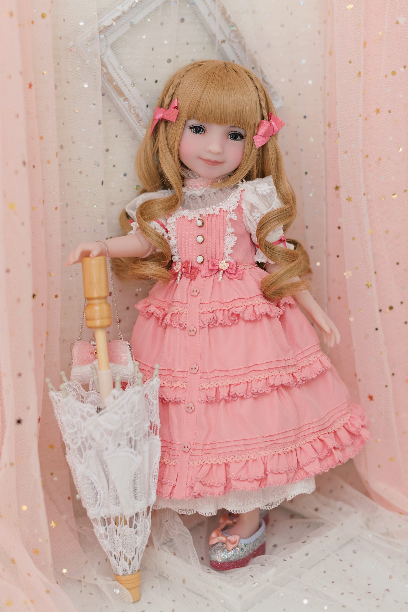 Doll in a pink dress holding a lace umbrella against a soft pink background