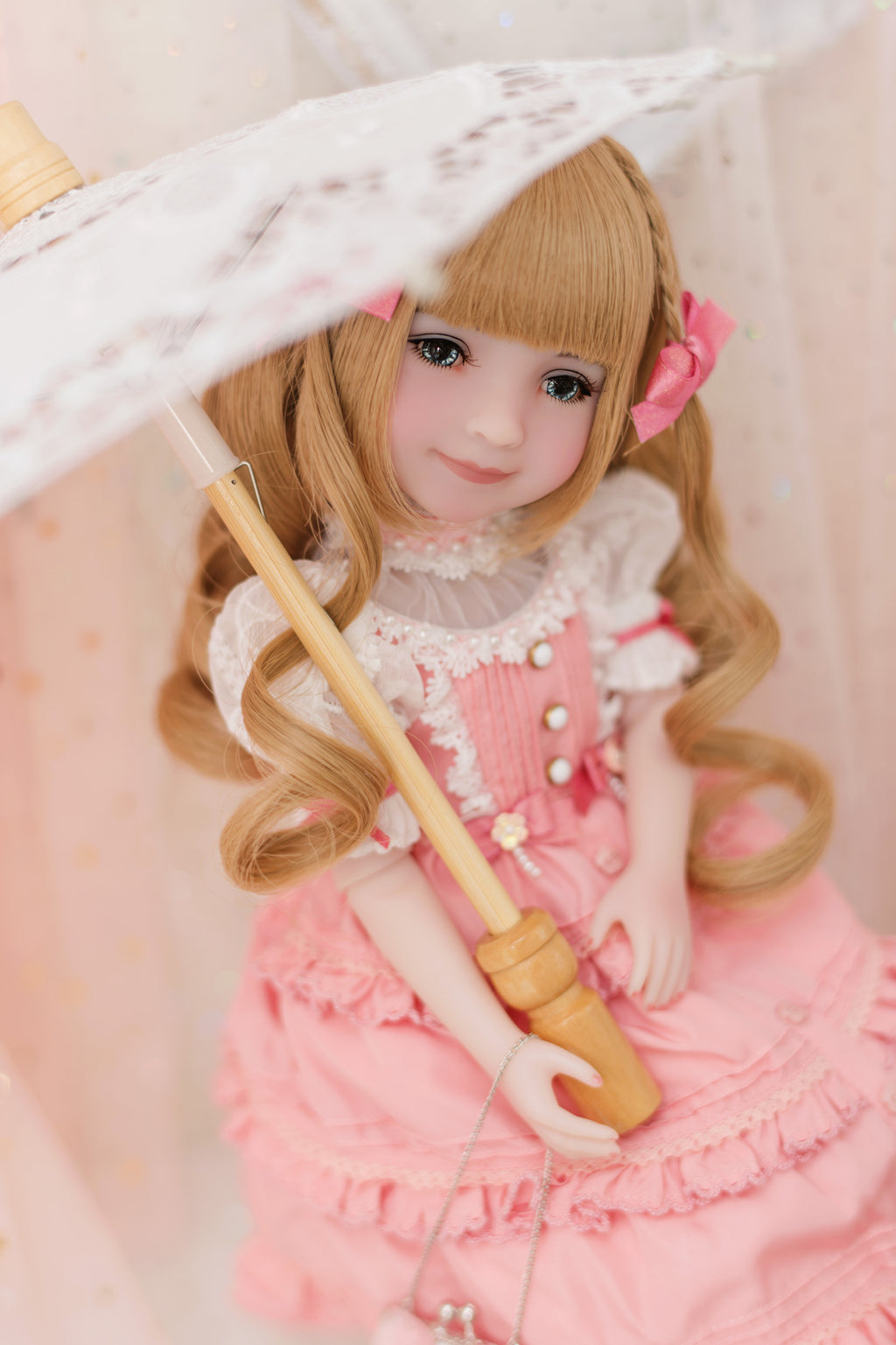  Doll in a pink outfit holding an umbrella on a light background