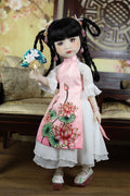 Traditional doll in a floral dress with a decorative fan, set against a decorative background.