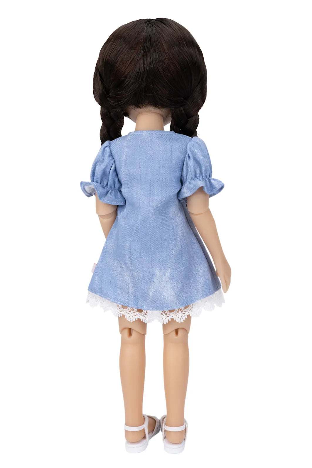 Doll wearing a blue dress with lace trim on a white background