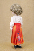 Doll wearing a traditional outfit with a red skirt and white top on a beige background