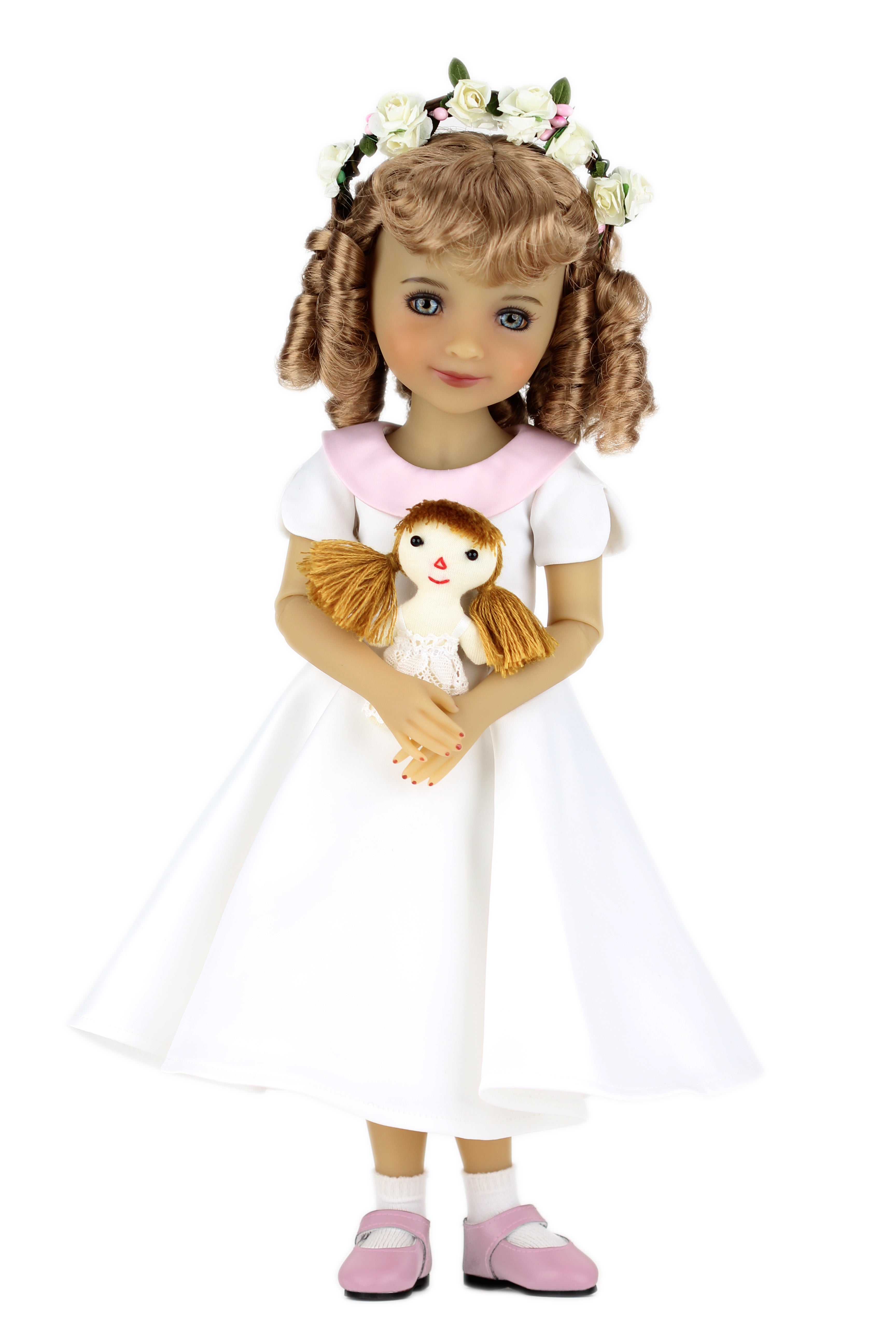 Doll in a white dress holding a smaller doll on a white background
